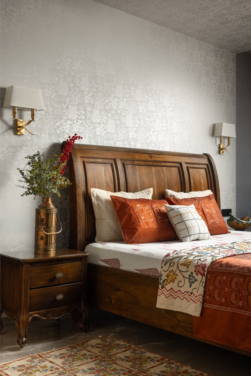 A Vastu-aligned bedroom with warm wood, terracotta textiles, and a brass lamp.