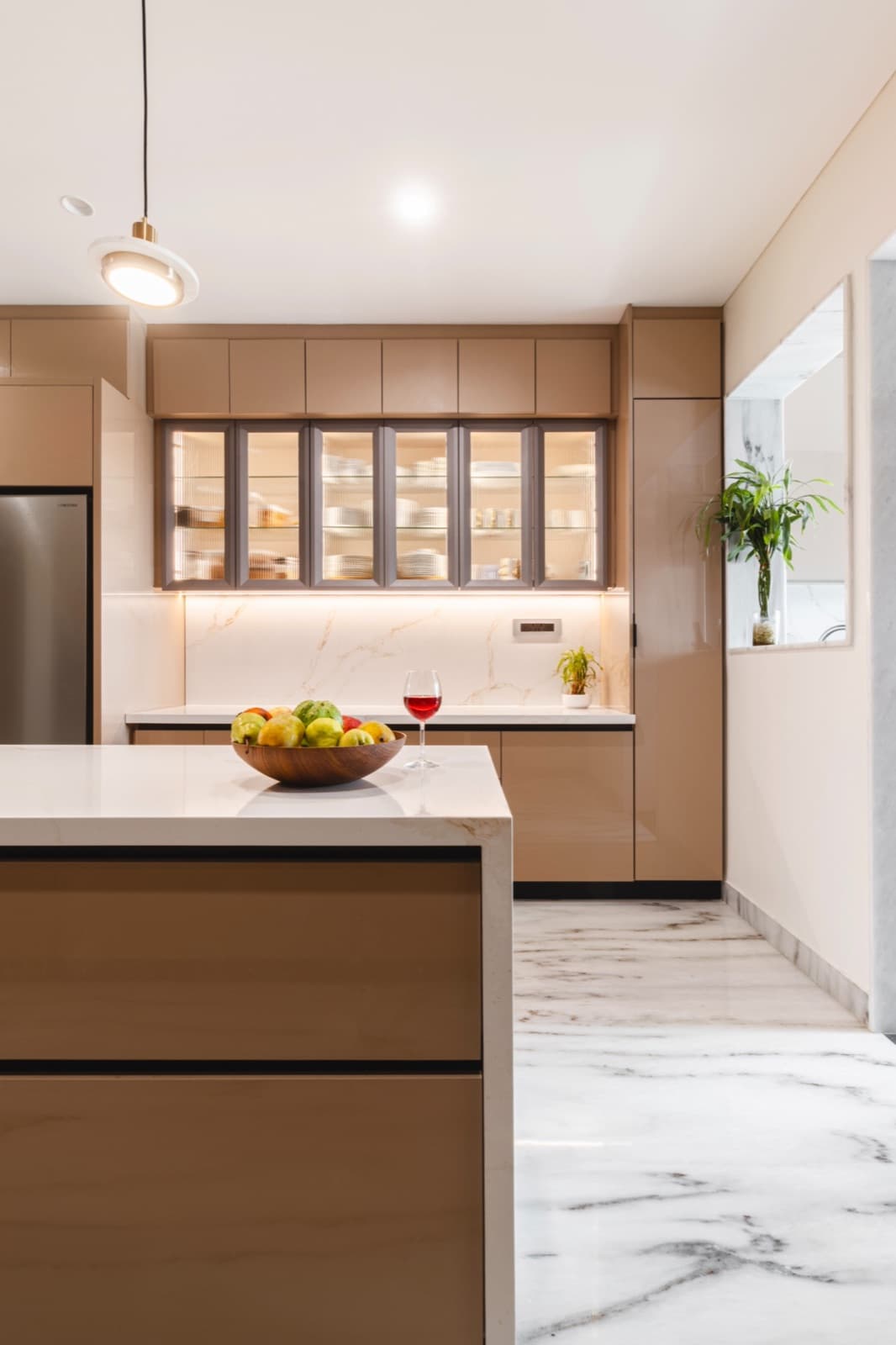 A clean modern kitchen with marble counters and warm natural light.